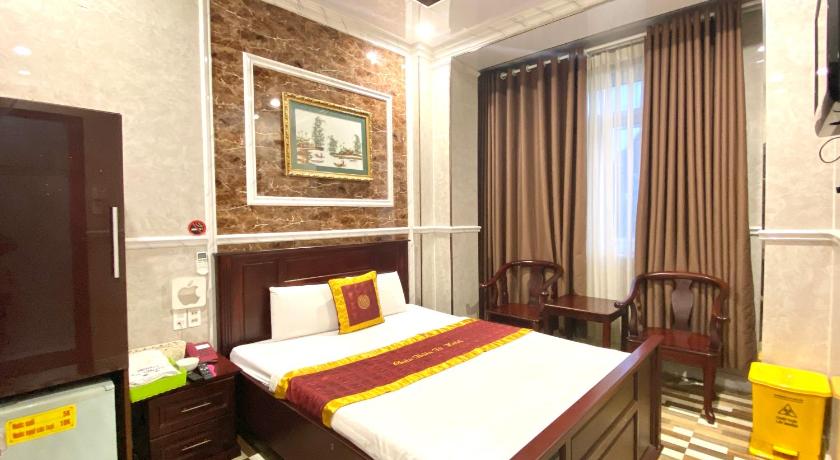 a bedroom with a large bed and a large window, RedDoorz Chau Thien Tu 3 Hotel in Ho Chi Minh City
