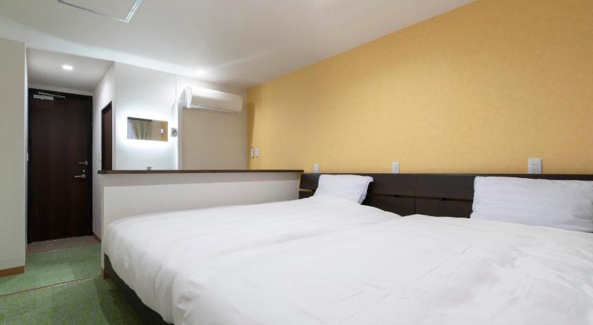 a hotel room with a white bed and white walls, Tabist Hotel Miyakonojo Miyazaki in Miyakonojo