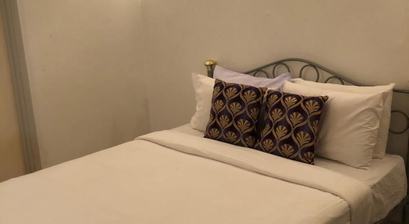 a white bed with a white comforter on top of it, Berjaya hills Sweet Homestay B210 in Bentong