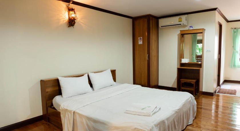 a hotel room with a bed and a dresser, Baan Kitsada in Amphawa (Samut Songkhram)