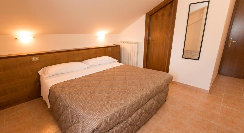 a bedroom with a bed and a dresser, Albergo Della Corte in Pescasseroli