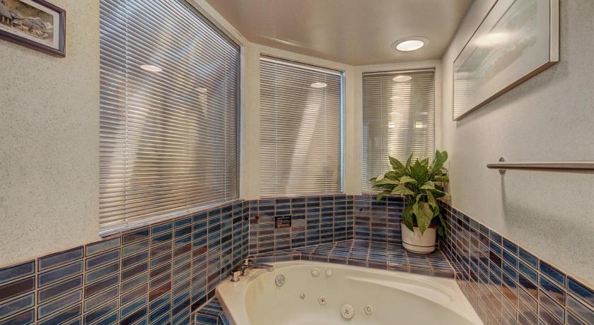 a white bath tub sitting under a window in a bathroom, Beaver Run Premium 1 Bedroom in Breckenridge (CO)