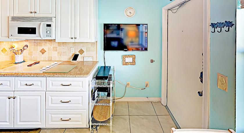 a kitchen with a refrigerator, stove, sink and microwave, Breezy Belleair 5E in Belleair Beach (FL)