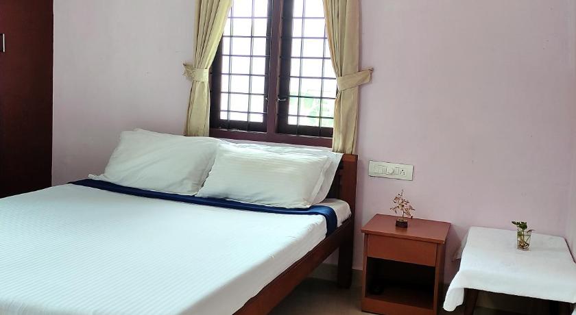 a bedroom with a bed and a window, Thanal Homestay in Kochi