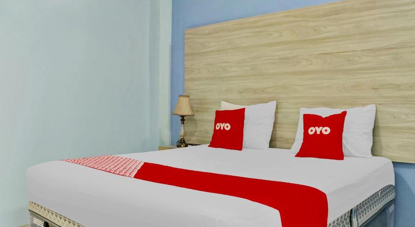 a hotel room with a bed and two lamps, RedDoorz near Taman Murjani in Banjarbaru