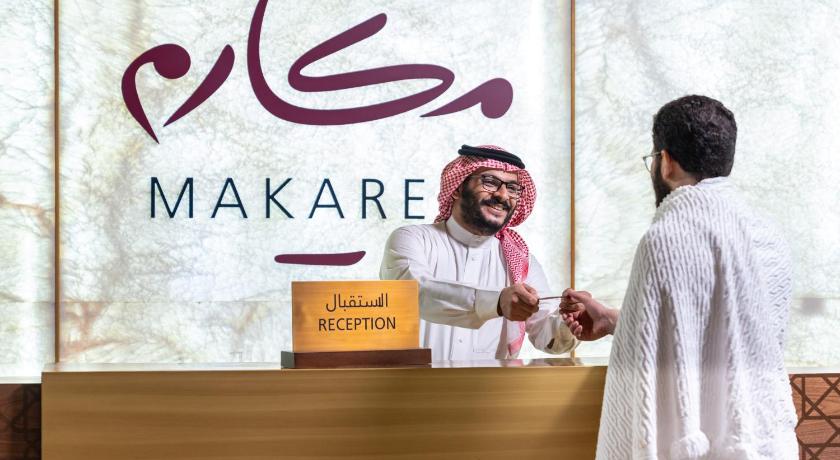 a man standing next to a woman in front of a sign, Makarem Ajyad Makkah Hotel in Mecca