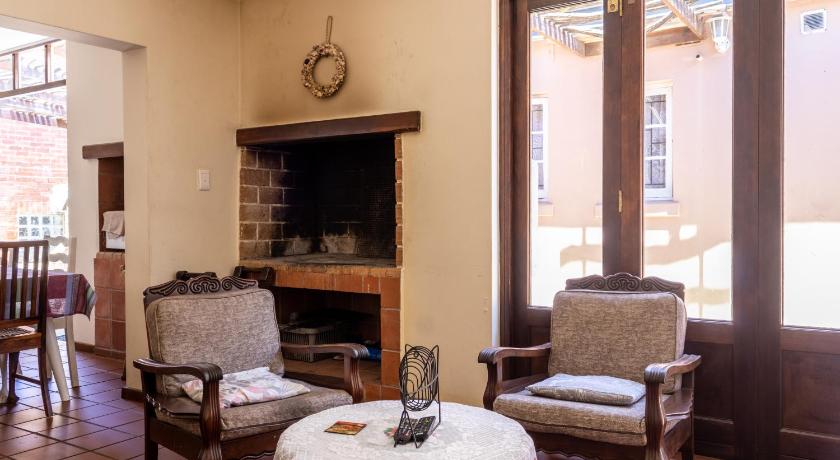a living room filled with furniture and a fireplace, Bay Vista Guesthouse in Mossel Bay