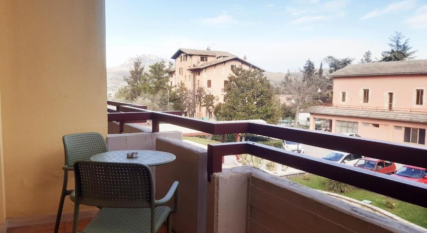 a room with a chair, table and a window, Hotel Pennile in Ascoli Piceno
