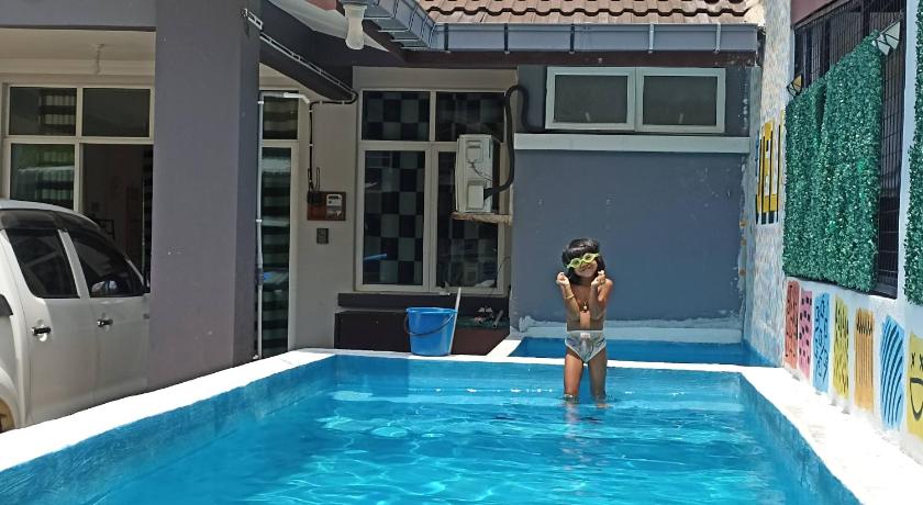 a woman standing in front of a swimming pool, Homestay Ayer Puteh @ Jeli Kelantan Private Pool in Tanah Merah