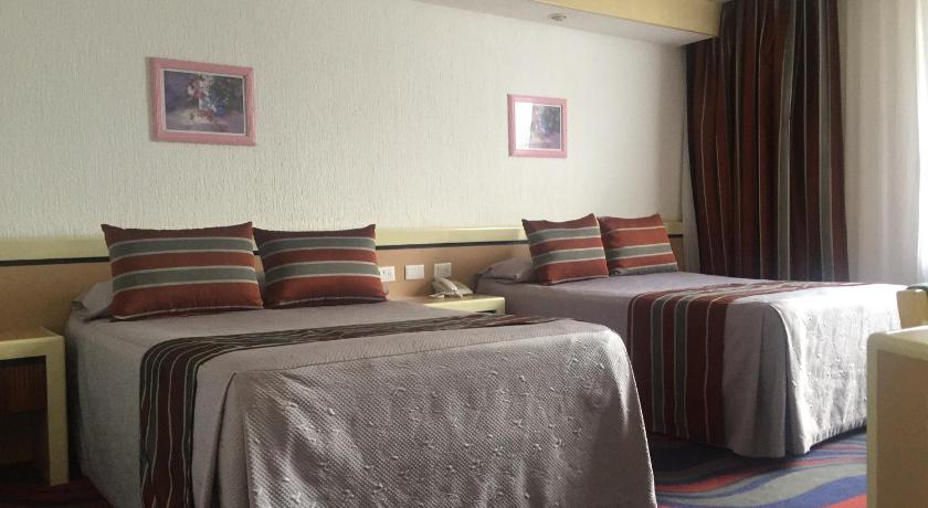 a cat laying on top of a bed in a room, Hotel Fleming in Mexico City