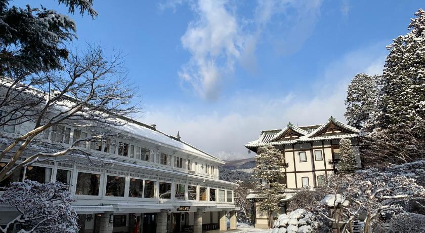 a large building with trees and snow covered ground, Nikko Kanaya Hotel in Nikko
