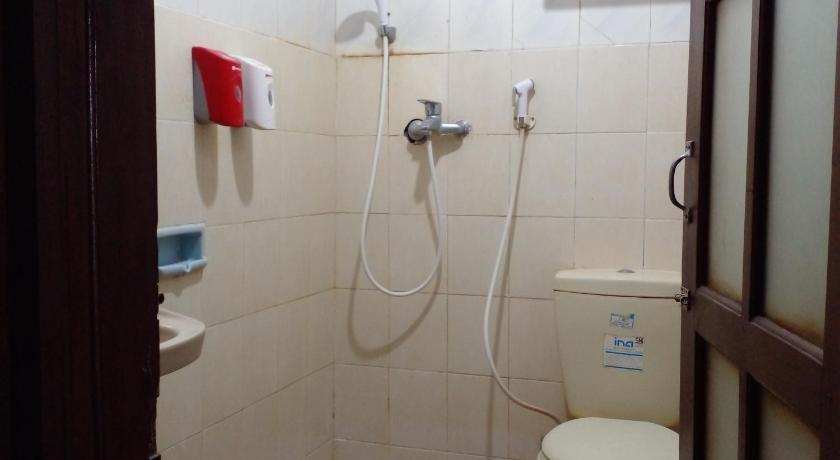 a bathroom with a toilet and a shower stall, Bifa Hotel in Yogyakarta
