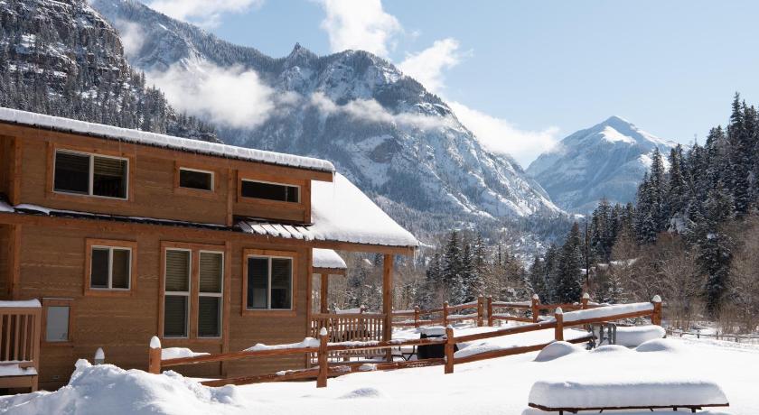 a large building with a snow covered mountain, Ouray Riverside Resort - Inn & Cabins in Ouray (CO)