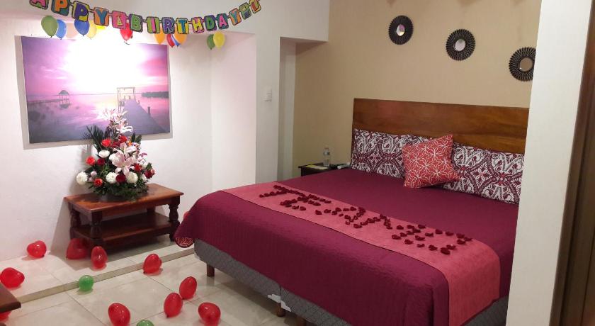 a bed room with a red bedspread and a pink bedspread, Hotel Casa Lima Bacalar in Bacalar