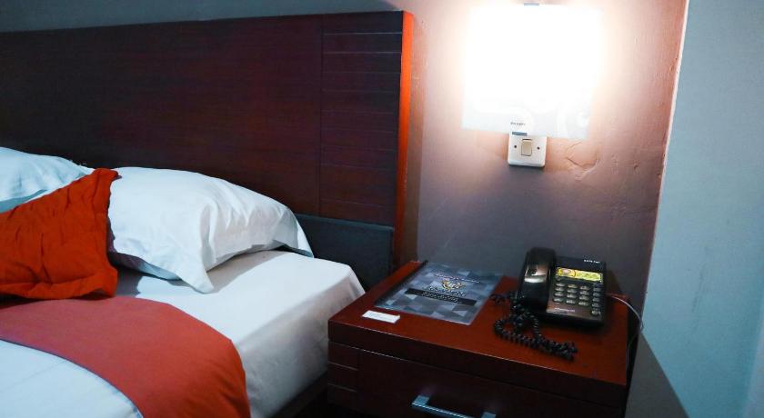 a bedroom with a bed and a lamp, Helios Hotel Malang in Malang
