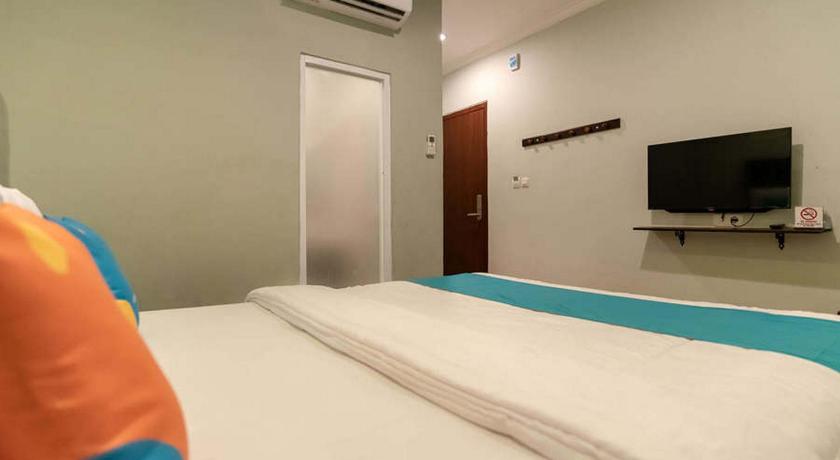 a hotel room with two beds and a television, Hotel Ta Ke Talang Banjar Jambi in Jambi