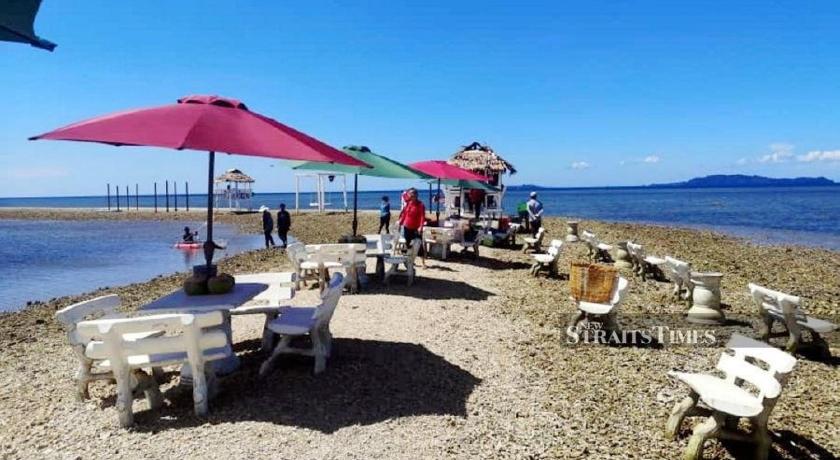 a beach area with tables, chairs and umbrellas, KAWASAN PELANCONGAN BORNEO in Kudat