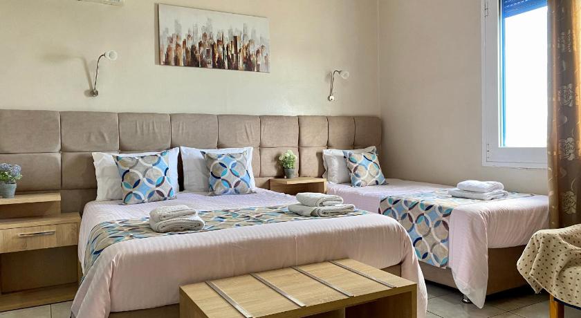 a bed room with two beds and a table, Pelineon Rooms in Chios