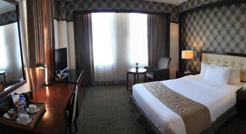 a hotel room with a large bed and a large window, The Plaza Hotel - Balanga in Bataan