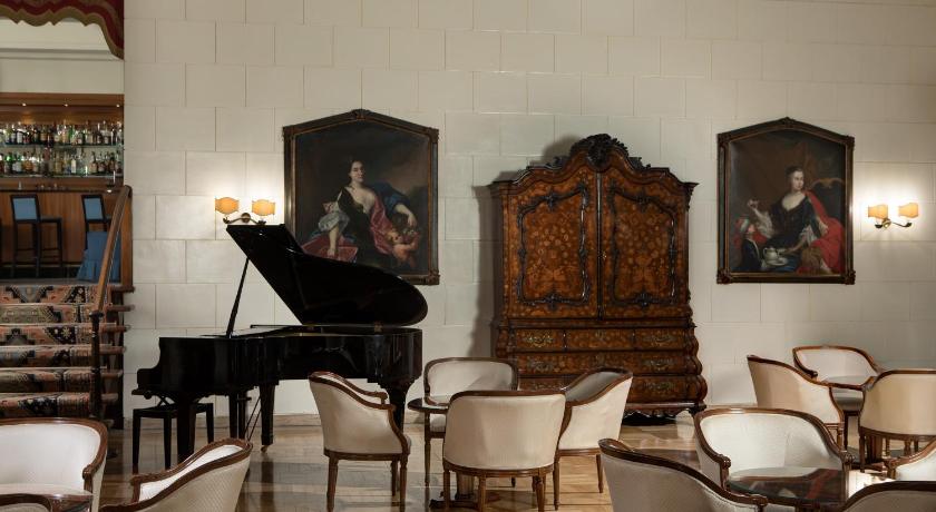 a living room filled with furniture and a piano, Quirinale Hotel in Rome