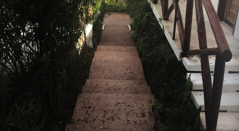 a row of wooden stairs leading to a garden, Hotel Aldea 19 Bacalar in Bacalar