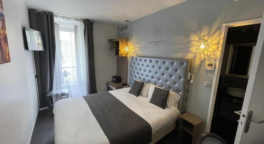 a hotel room with a bed and two lamps, Hotel de Paris Montmartre in Paris