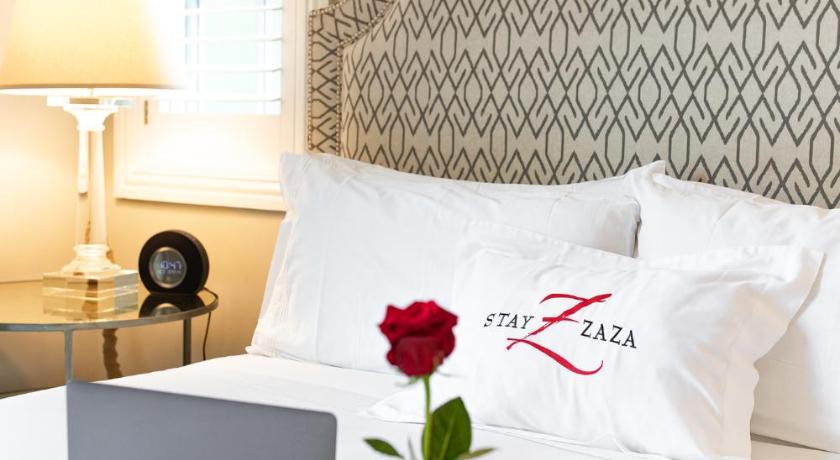 a white bed with a laptop on top of it, Hotel ZaZa Dallas in Dallas (TX)