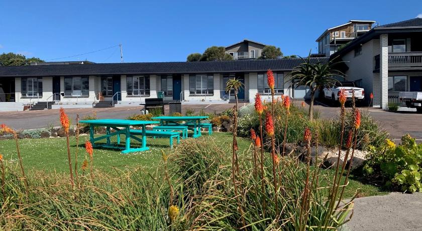 a green bench sitting in front of a house, Southern Ocean Motor Inn in Great Ocean Road - Port Campbell
