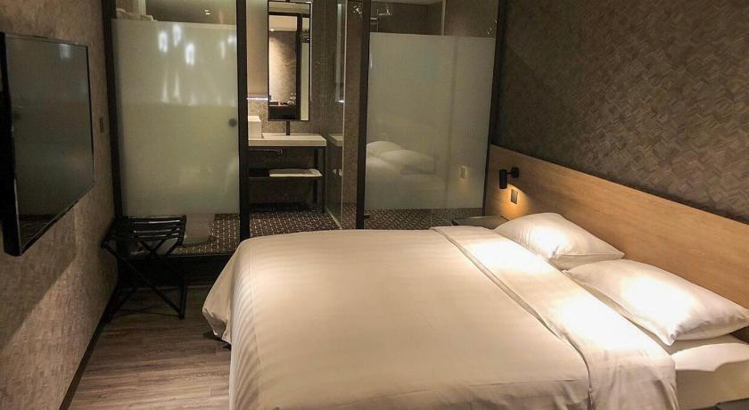 a hotel room with a bed and a desk, City Suites-Taoyuan Station in Taoyuan