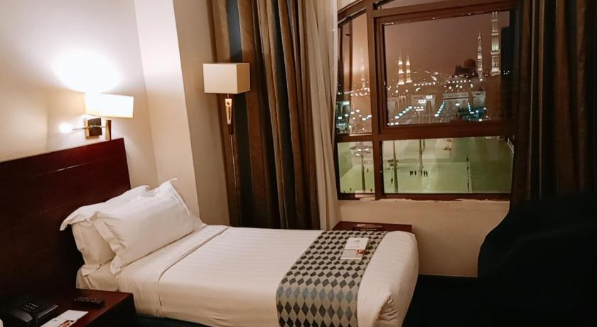 a hotel room with a large bed and a large window, Rawdat Al Aqiq Hotel in Medina