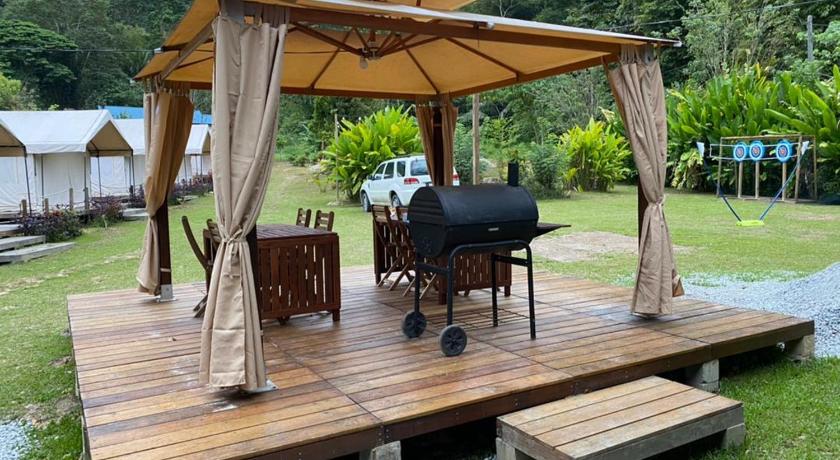 a wooden table topped with an umbrella and chairs, Canopy Villa Tampik Valley in Bentong