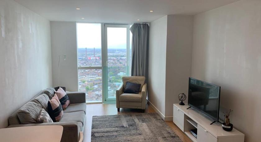 a woman laying on a couch in a living room, GRAND SERVICED APARTMENTS***** in London
