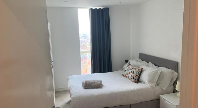 a bedroom with a white bed and a white wall, GRAND SERVICED APARTMENTS***** in London