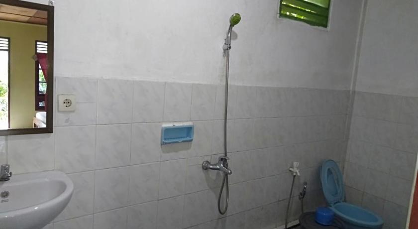 a bathroom with a toilet, sink, and shower, Sibayak Guesthouse in Samosir