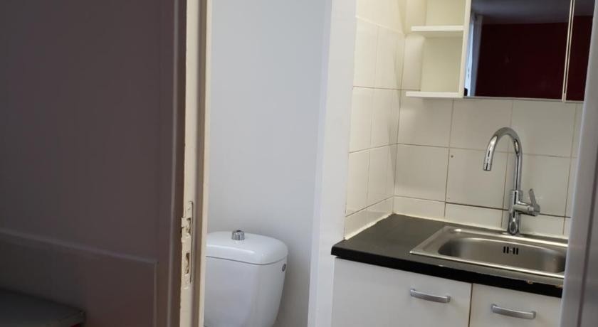 a white kitchen with a white toilet and sink, LE CEDRE in Paris