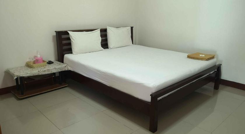 a bed in a room with a white bedspread, Pruksa Resort Prachin Buri in Prachinburi