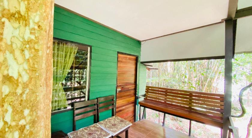 a wooden bench in a room with green walls, Khaosok Treehouse Resort in Khao Sok (Suratthani)