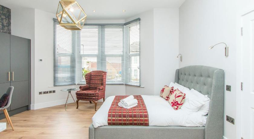 a bedroom with a bed, chair and a window, Coldharbour Suites in Bristol