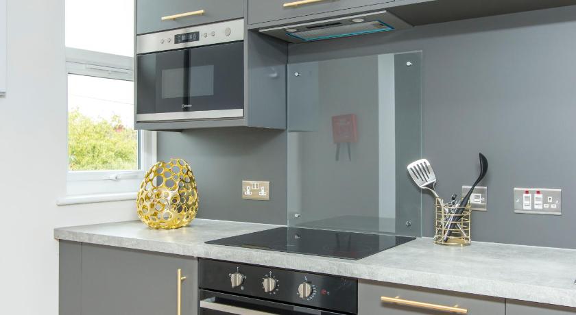 a kitchen with a stove top oven and a microwave, Coldharbour Suites in Bristol