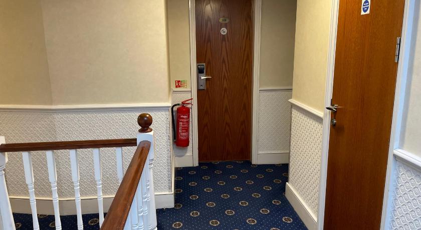 a hallway with stairs leading up to a staircase, Orchard Hotel in London