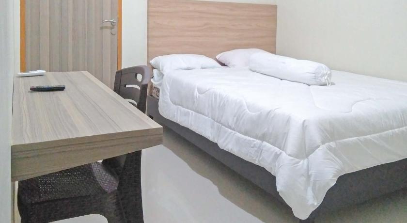 a hotel room with two beds and a desk, RedDoorz Syariah @ Karema Area Mamuju in Mamuju