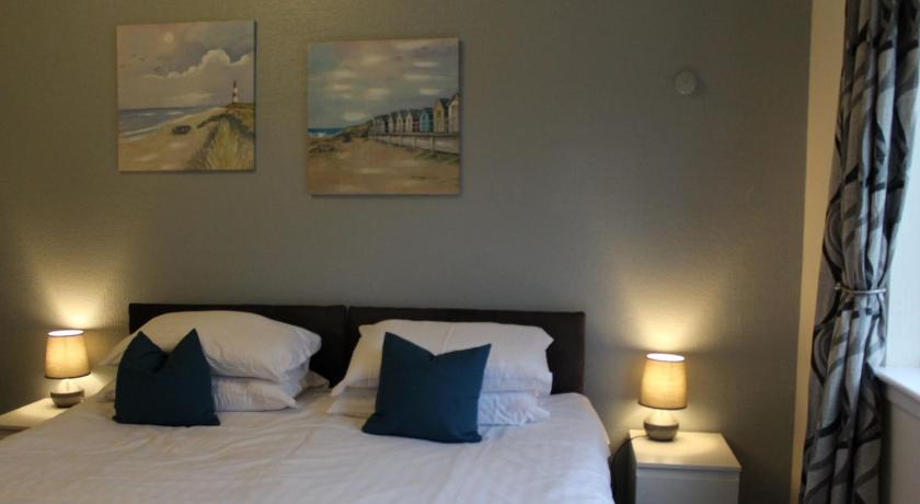 a bedroom with a bed, a lamp and a painting on the wall, The Woodhouse Hotel in Largs