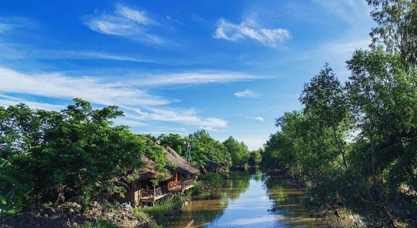 a river filled with lots of water next to a forest, Hometravel Mekong Can Tho in Cần Thơ