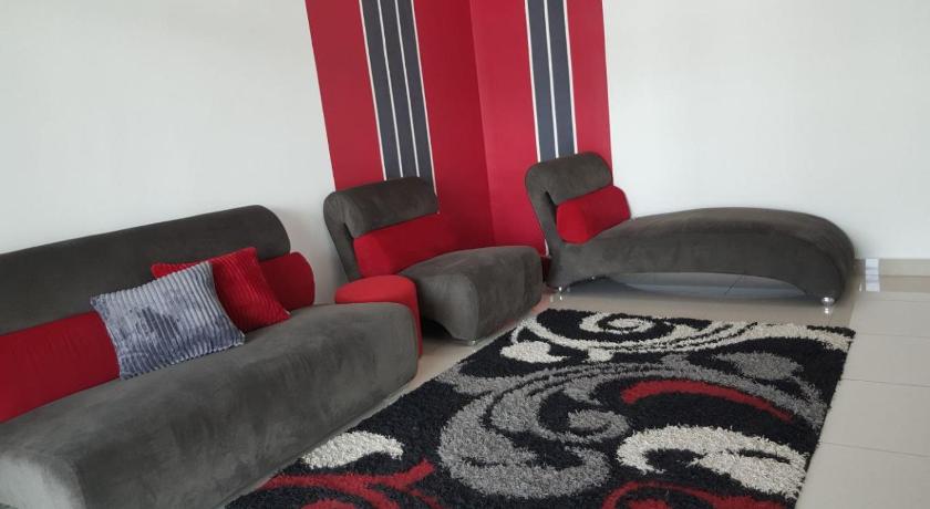 a living room filled with furniture and a red couch, Embon Homestay in Padang Serai