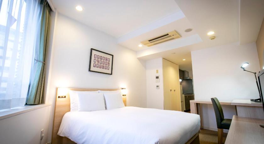 a hotel room with a white bed and white walls, Residential Hotel B:CONTE Asakusa in Tokyo