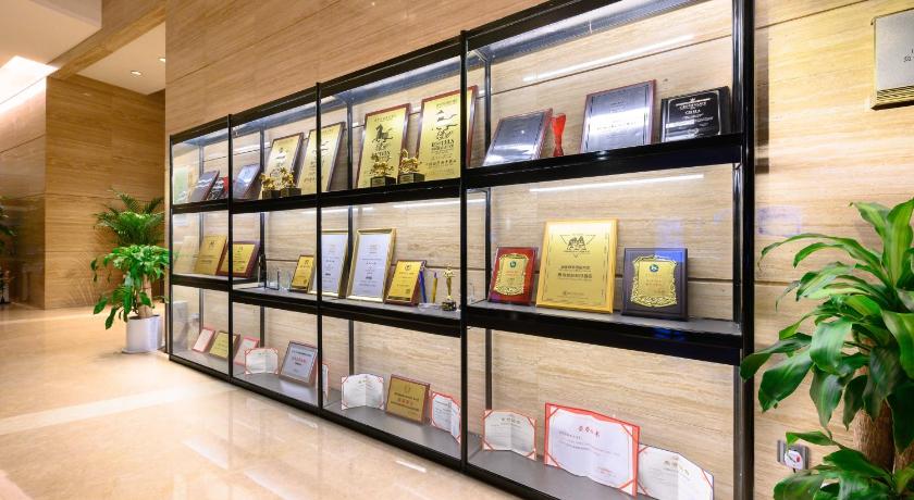 a display of books on a shelf in a room, Crowne Plaza Huizhou in Huizhou