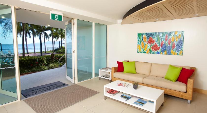 a living room filled with furniture and a large window, Mariners North Holiday Apartments in Townsville