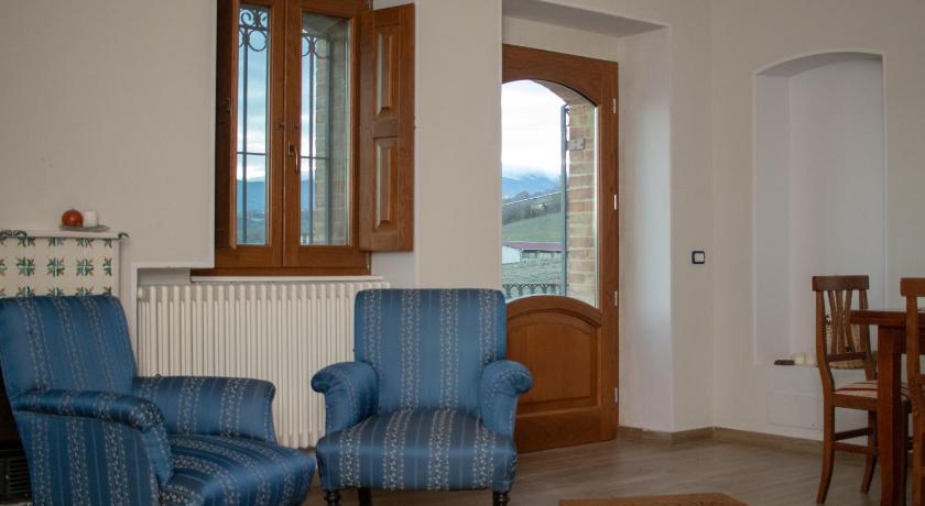 a living room filled with furniture and a blue chair, Albergo Diffuso La Piana dei Mulini in Colle d' Anchise