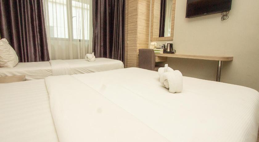 a white bed sitting in a hotel room next to a window, GM Grand Moments in Kuala Lumpur