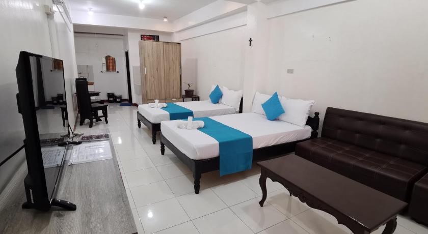 a hotel room with two beds and a television, JPrime Apartelle in Tuguegarao City